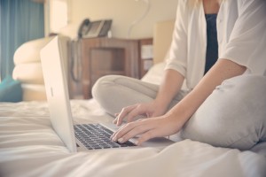 girl with laptop on bed