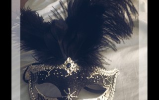 Silver mask with large black feathers on top
